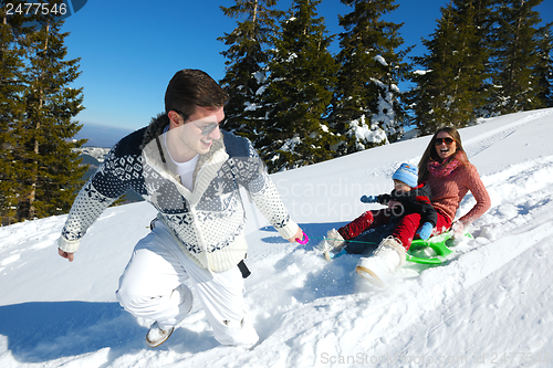 Image of family having fun on fresh snow at winter