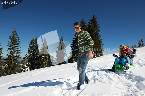 Image of family having fun on fresh snow at winter