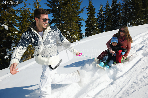 Image of family having fun on fresh snow at winter