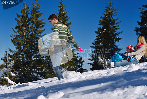 Image of family having fun on fresh snow at winter