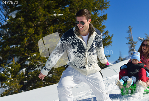 Image of family having fun on fresh snow at winter