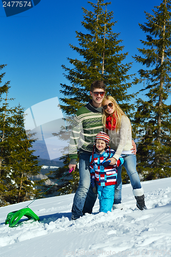 Image of family having fun on fresh snow at winter