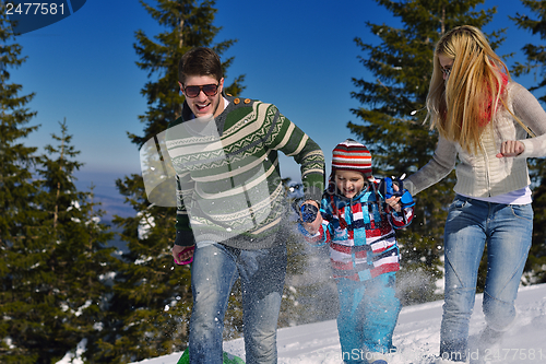 Image of family having fun on fresh snow at winter