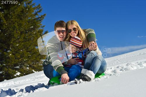 Image of family having fun on fresh snow at winter