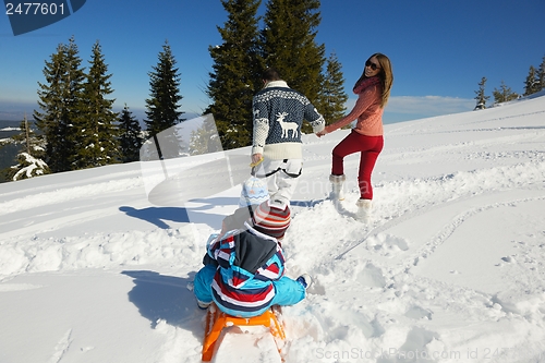Image of family having fun on fresh snow at winter
