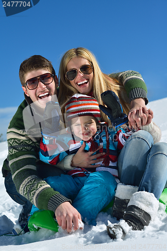 Image of family having fun on fresh snow at winter