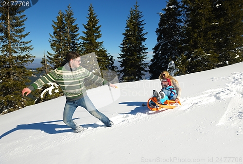 Image of family having fun on fresh snow at winter