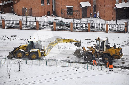 Image of Special equipment on road construction. Snowfall.