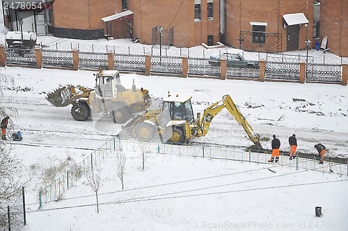 Image of Special equipment on road construction. Snowfall.