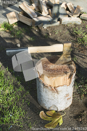 Image of Ax chopping wood on chopping block