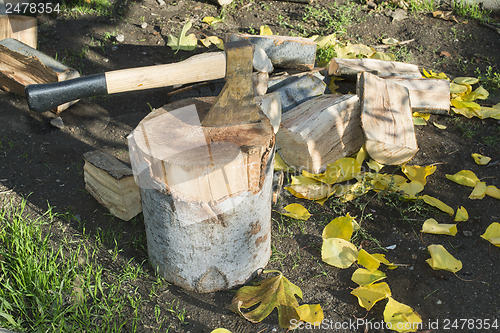 Image of Ax chopping wood on chopping block