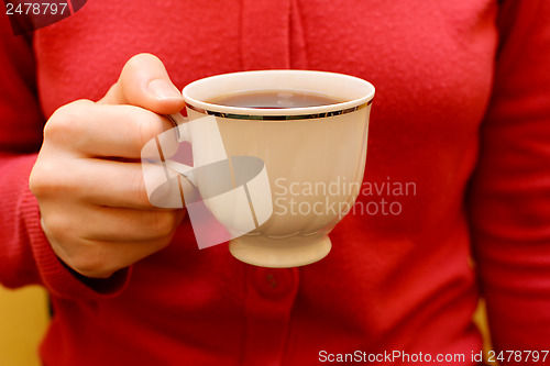 Image of Woman with a cup of black tea in her hand