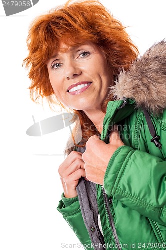 Image of redhead smiling adult mature woman with geen warm jacket