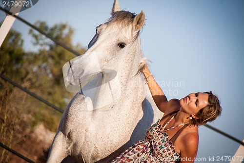 Image of young woman walking a road with horse