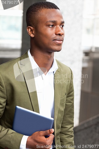 Image of smiling successful businessman with tablet pc outdoor