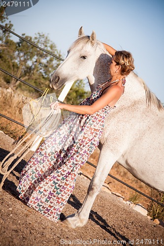 Image of young woman walking a road with horse