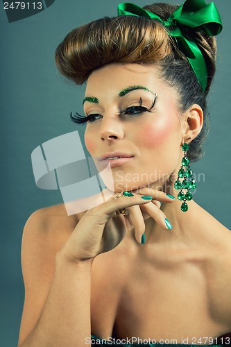 Image of brunette woman with green jewelery and accssesoires