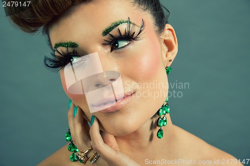 Image of brunette woman with green jewelery and accssesoires