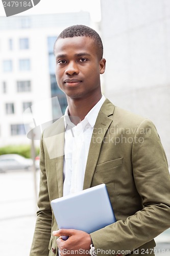 Image of smiling successful businessman with tablet pc outdoor