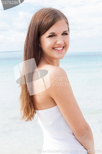 Image of smiling young brunette woman in summer on the beach 