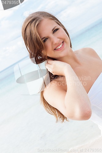 Image of smiling young brunette woman in summer on the beach 