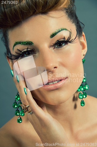 Image of brunette woman with green jewelery and accssesoires