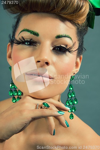 Image of brunette woman with green jewelery and accssesoires