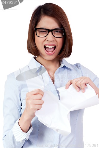 Image of young frustrated asian business woman with paperwork crumpled