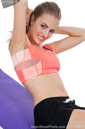 Image of young attractive woman doing sit ups in sportswear isolated