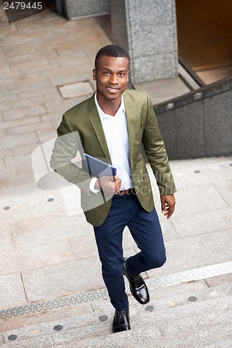 Image of smiling successful businessman with tablet pc outdoor