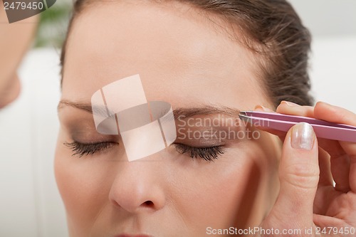 Image of young beautiful woman eyebrow plucking tweezers eyes hair 
