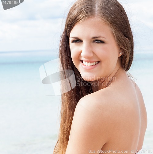 Image of smiling young brunette woman in summer on the beach 