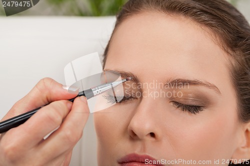 Image of young attractive woman makeup eyebrow powder shadow applying