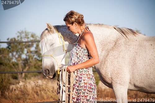 Image of young woman walking a road with horse