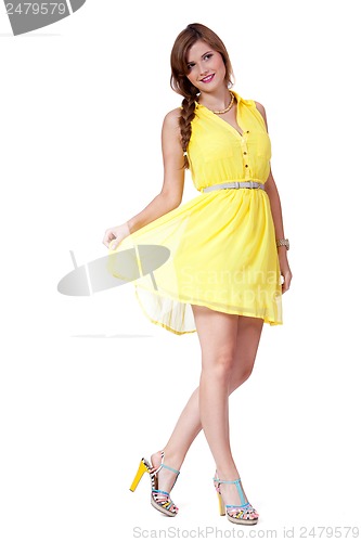 Image of smiling young brunette woman in yellow dress isolated