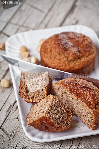 Image of sliced fresh buns, old knife and hazelnuts 