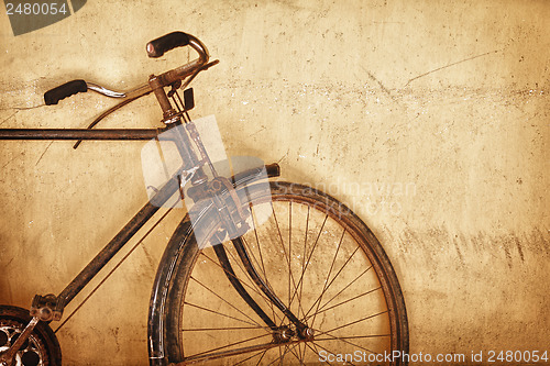 Image of Old-fashioned rusty bicycle near the wall