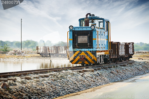 Image of Old small blue locomotive and freight train