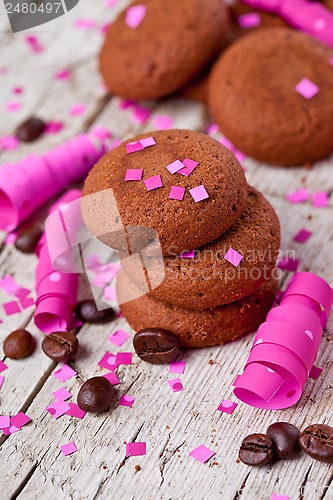 Image of fresh chocolate cookies, coffee beans, pink ribbons and confetti