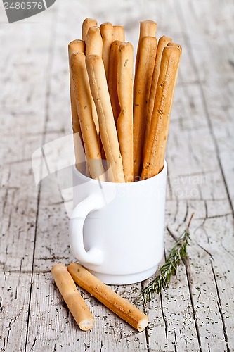 Image of cup with bread sticks grissini and rosemary