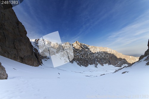 Image of Two hikers on snowy mountains in morning