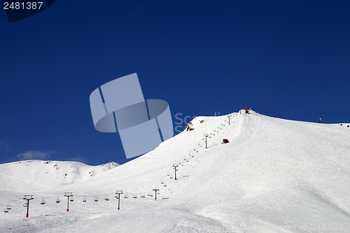 Image of Ski slope with ropeway at sun winter day