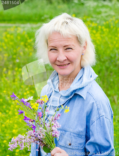 Image of Portrait of a middle-aged woman with a bouquet of wild flowers