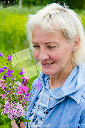 Image of Portrait of a middle-aged woman with a bouquet of wild flowers