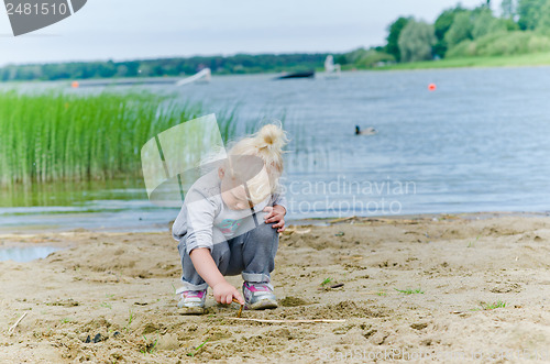 Image of  Boy and girl playing in the sand on the shore of Lake 