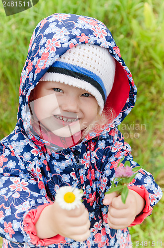 Image of Portrait of a little girl with wild flowers in the hands  