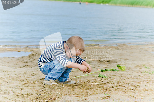 Image of  Boy and girl playing in the sand on the shore of Lake 