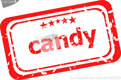 Image of candy on red rubber stamp over a white background