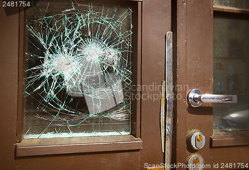 Image of Broken window on  door by vandalism