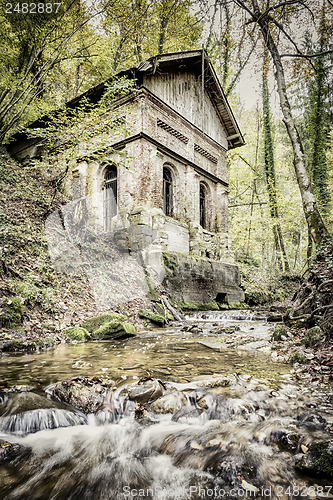 Image of Creek in forest with old house